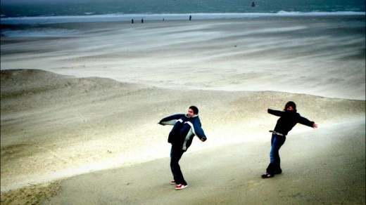 Twee jongeren tijdens een zuidwesterstorm op het strand van Vlissingen (archief)
