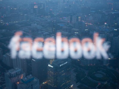 A photo taken on May 16, 2012 shows a computer screen displaying the logo of social networking site Facebook reflected in a window before the Beijing skyline | Foto Ed Jones/AFP/GettyImages