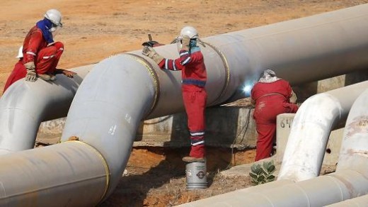 Oil workers weld a new pipeline at PDVSA's Jose Antonio Anzoategui industrial complex in the state of Anzoategui, Venezuela | Reuters