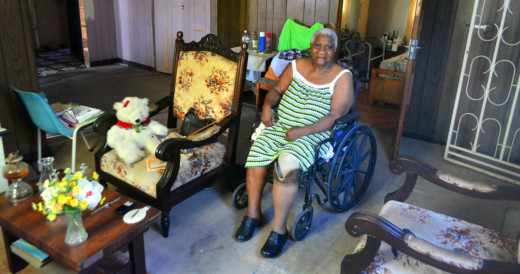 Catherine Mitchel in haar woonkamer. Met rolstoel en prothese | Persbureau Curacao