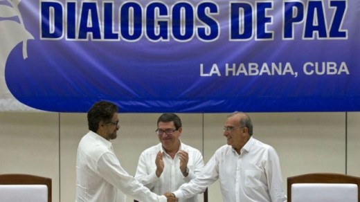 Colombian government negotiator Humberto de la Calle (R) and his Farc counterpart Ivan Marquez (L) signed the agreement, applauded by Cuban Foreign Minister Bruno Rodriguez 