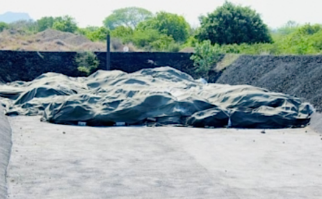Op deze archieffoto uit 2013 is een bassin te zien waar zakken met asbesthoudend bouwafval in afgedekt zijn. Volgens de Isla hadden metaaldieven hierin gewroet op zoek naar metaal. Het terrein bevat vele bassins waarin afval begraven ligt