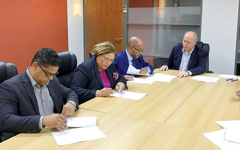 Ministers (from left to right) Eugene Rhuggenaath, Suzanne Camelia-Römer and Kenneth Gijsbertha signing the loan agreement | Daily Herald