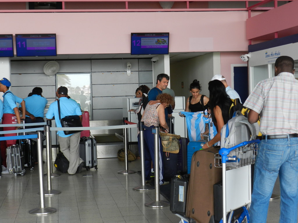 Passagiers wachten bij het inchecken op Flamingo Airport | foto Belkis Osepa
