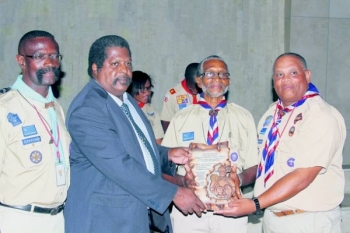 Hopman Ezequiel Calmes (derde van links) krijgt uit handen van vicepremier Bernard Ben Whiteman (Gezondheid, Milieu en Natuur, PS) een plakkaat overhandigd. De Koempoelan 2013 wordt aan Calmes opgedragen vanwege zijn jarenlange inzet voor de scouting op Curaçao.