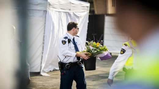 Een agent zet bloemen neer bij juwelier Goldies ©ANP