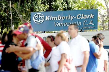 Werknemers wachten voor de Kimberly-Clark fabriek in Maracay. foto: Reuters